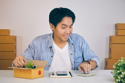 Young man looking away while sitting on table