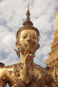 Low angle view of buddha statue against sky