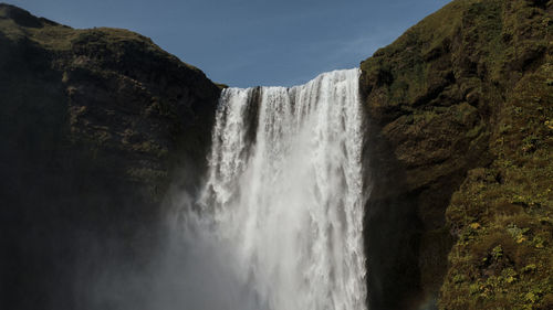 Scenic view of waterfall against sky