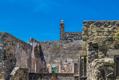 Low angle view of old building against blue sky. castle aragonese at ischia in italy 