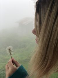 Close-up of woman holding dandelion
