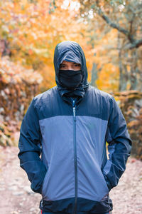 Man standing against trees in forest