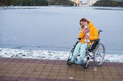 Caucasian woman in a wheelchair walks the dog in winter