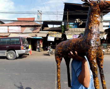 Man carrying representation of a deer