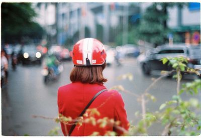 Rear view of woman wearing cycling helmet on street in city