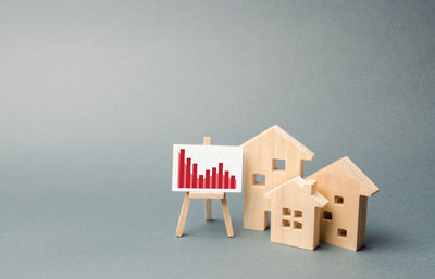 Wooden houses with a stand of graphics and information. concept of real estate value decrease.