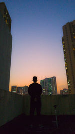 Rear view of a man with cityscape in background