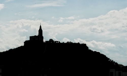 Low angle view of silhouette building against sky