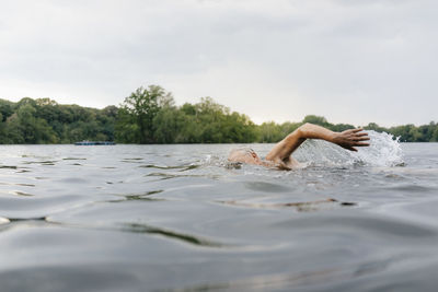 Senior man swimming in a lake