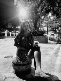 Portrait of smiling young woman sitting outdoors