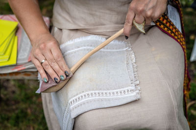 Midsection of woman cleaning wooden spoon