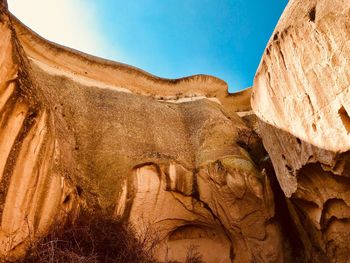 Low angle view of sun shining through rocks