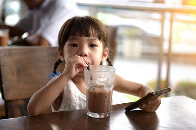 Portrait of girl holding drink in restaurant