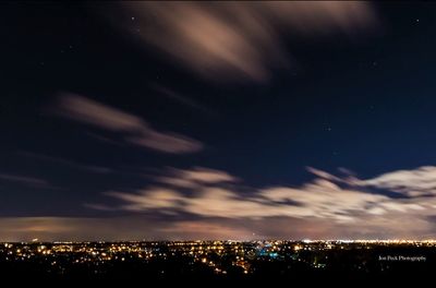 Illuminated cityscape against sky at night