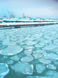 Scenic view of harbor against sky during winter