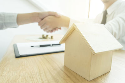 Close-up of businessman and client shaking hands in office