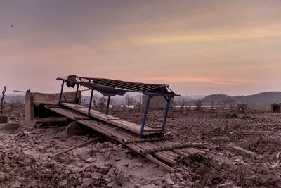 Abandoned structure against sky during sunset