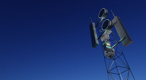 Low angle view of communications tower against blue sky