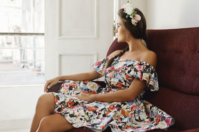 Young woman sitting on sofa at home