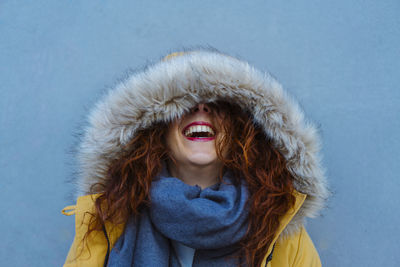 Smiling young woman against wall