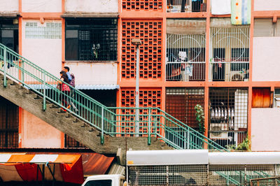 People walking on staircase by building