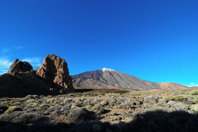 Scenic view of rocky mountains against clear blue sky