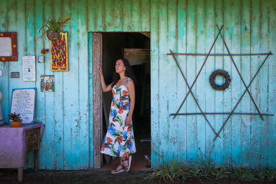 Young woman standing against a wooden wall