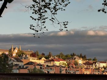 View of buildings in city against cloudy sky