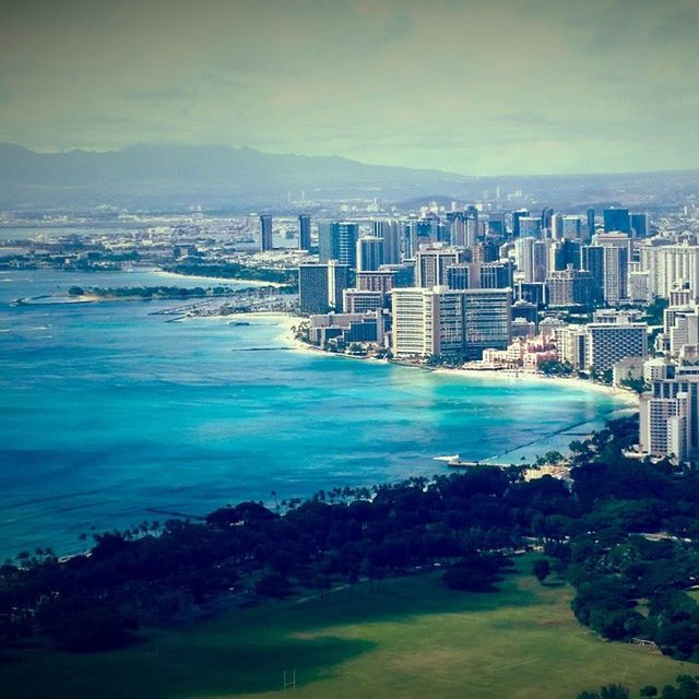 building exterior, architecture, built structure, water, sea, city, cityscape, sky, tree, residential building, high angle view, coastline, residential district, residential structure, scenics, beach, blue, cloud - sky, nature, skyscraper