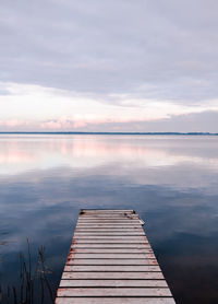 Pier over lake against sky during sunset