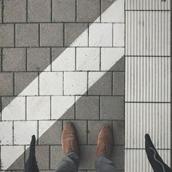 Low section of man standing on cobblestone