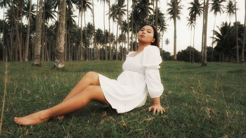 Portrait of young woman sitting on field