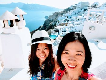 Portrait of smiling family standing against houses on mountain