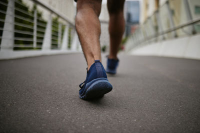 Low section of man standing on road