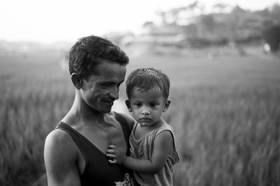 Portrait of father and son on field