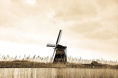 Traditional windmill on field against sky