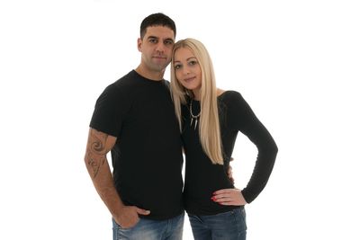 Portrait of young couple standing against white background