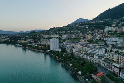 High angle view of townscape by sea against clear sky