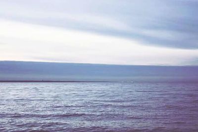 Scenic view of sea against cloudy sky