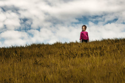 Woman standing on field against sky