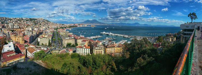 High angle view of town by sea against sky