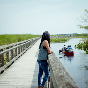 Rear view of man on river against sky