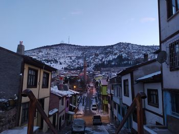 Houses in town against sky at dusk