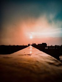 Surface level of water against sky during sunset