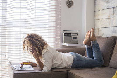 Man using mobile phone while sitting on sofa at home