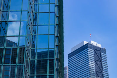 Low angle view of modern buildings against clear blue sky