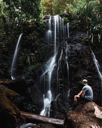 Full length of waterfall on rocks in forest