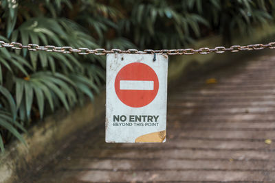 Close-up of information sign hanging on metal