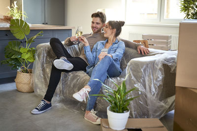 Side view of woman sitting on sofa at home