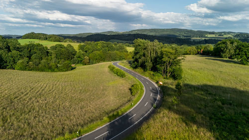 Road amidst field against sky
